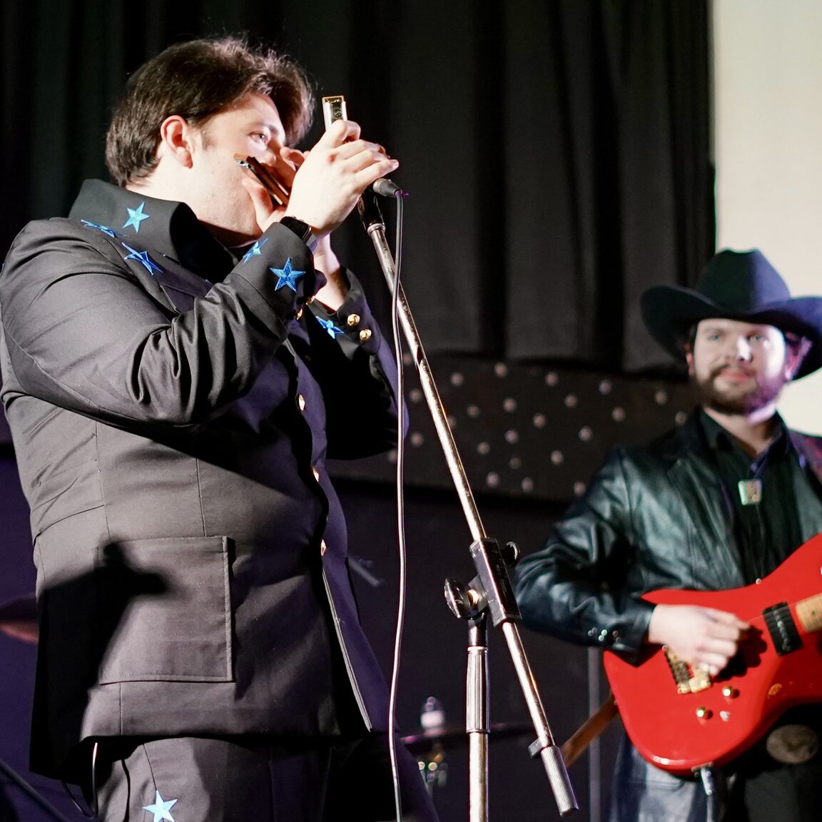 Austin T. O'Keefe Canadian Singer-Songwriter in an Elvis-style blue star suit performing live with his harmonica.
