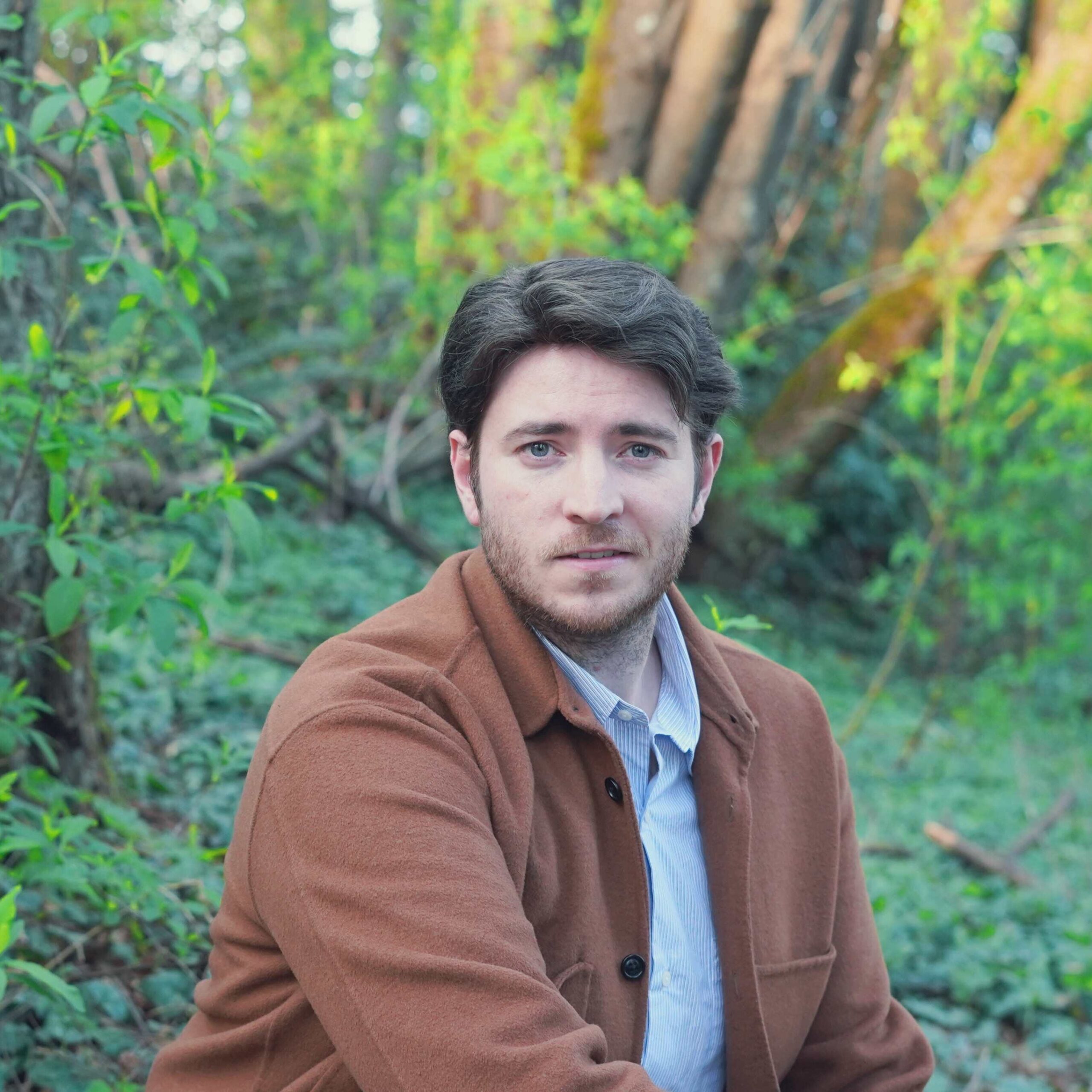 Austin T. O'Keefe, Canadian singer-songwriter, posing in a natural forest setting for promotional press kit.